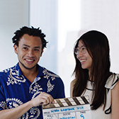 D. E. Shaw employees holding a clapperboard during a video production shoot.